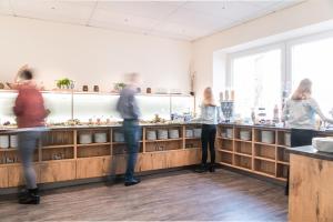 a group of people standing at a counter in a restaurant at LIHO - einfach Lübeck in Lübeck
