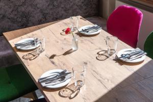 a wooden table with plates and glasses and a flower in a vase at LIHO - einfach Lübeck in Lübeck