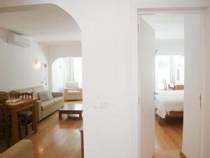 カルヴォエイロにあるCarvoeiro Beach Apartment Luxuryのベッド1台とリビングルームが備わる客室です。