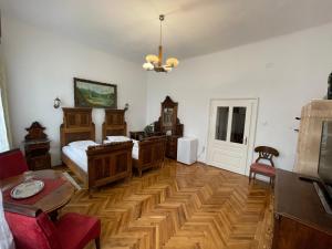 Schlafzimmer mit Holzböden, einem Bett und einem Tisch in der Unterkunft Guest House Hena in Sfântu Gheorghe