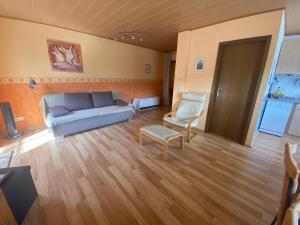 ein Wohnzimmer mit einem Sofa und einem Stuhl in der Unterkunft Haus Erika/ Fam. Frevel in Kattenes