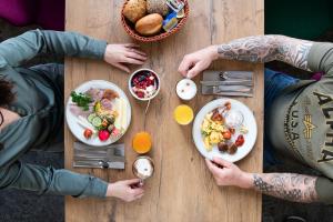 a group of people sitting around a wooden table with food at LIHO - einfach Lübeck in Lübeck