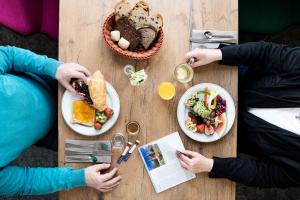 two people sitting at a table with plates of food at LIHO - einfach Lübeck in Lübeck