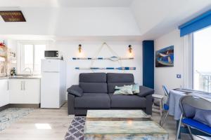 ein Wohnzimmer mit einem Sofa und einem Tisch in der Unterkunft Home2Book Sea Front Attic Las Galletas in Las Galletas
