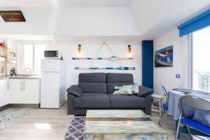 a living room with a couch and a table at Home2Book Sea Front Attic Las Galletas in Las Galletas