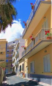 a building with flowers on the balcony of it at La Casa del Professore in Santa Teresa di Riva