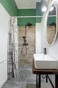 een badkamer met een wastafel en een douche bij Niron Apartament Dom z Papieru Nairobi in Piła