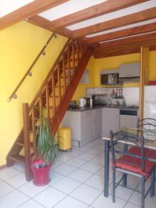 une cuisine avec un escalier, une table et des chaises dans l'établissement Villa Le Mauret, à Andernos-les-Bains