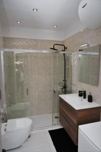 a bathroom with a shower and a toilet and a sink at Koules Sea View City Apartment in Heraklio