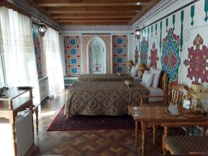 a bedroom with a bed in a room with colorful walls at Sasha & Son Hotel in Bukhara