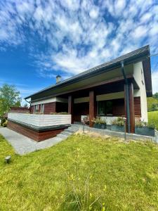 een huis met een grasveld ervoor bij Domki&Apartamenty Koszarka in Gródek Nad Dunajcem