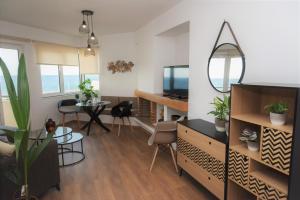 salon z telewizorem i stołem z krzesłami w obiekcie Koules Sea View City Apartment w Heraklionie
