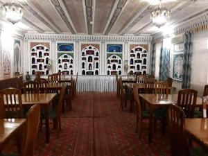 a restaurant with tables and chairs in a room at Sasha & Son Hotel in Bukhara