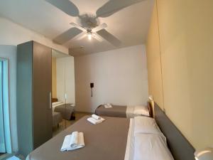 una camera con letto e ventilatore a soffitto di Hotel Britta a Rimini