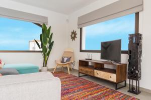 Una sala de estar con televisión y un sofá. en CASA CABRA, en Villaverde