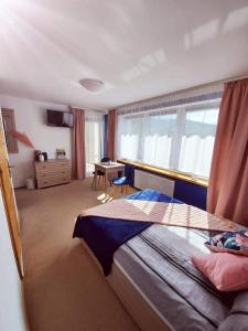 a bedroom with a bed and a desk and a window at Pokoje gościnne "Trudziń-SKI" in Świeradów-Zdrój