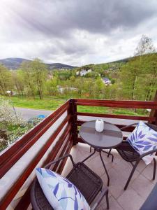 a patio with a table and chairs on a balcony at Pokoje gościnne "Trudziń-SKI" in Świeradów-Zdrój