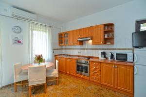 una cocina con armarios de madera y una mesa con sillas. en Apartments Porec 336 en Poreč