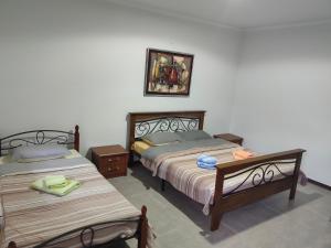 1 dormitorio con 2 camas y una foto en la pared en Art Hotel Al Hayat en Kaji-Say