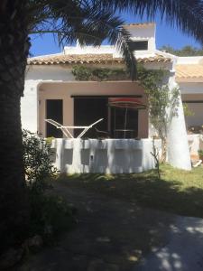 een wit huis met een palmboom ervoor bij Cala Serena Beach 1 in Cala Serena