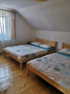 two twin beds in a room with a window at The Wooden House in Moldoveneşti