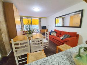 a living room with a table and a red couch at Apartamento America in Lloret de Mar