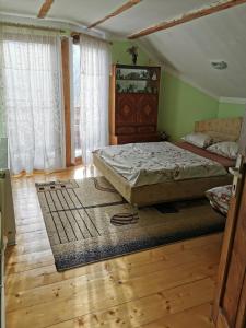 a bedroom with a bed and a wooden floor at The Wooden House in Moldoveneşti