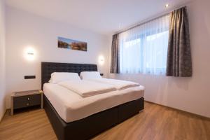 Un dormitorio con una cama grande y una ventana en Arlalps Apart, en Pettneu am Arlberg