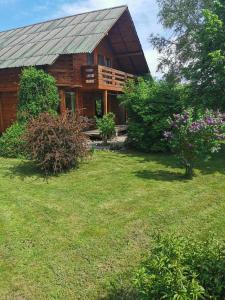 a log cabin with a yard in front of it at The Wooden House in Moldoveneşti