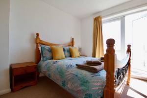 a bedroom with a bed and a large window at Seaview Beach house stones throws from the sea in Seaford