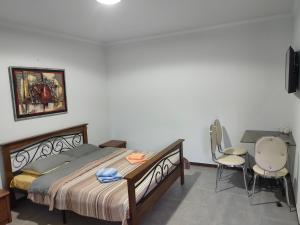 1 dormitorio con 1 cama, escritorio y sillas en Art Hotel Al Hayat en Kaji-Say