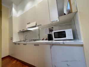 a kitchen with white cabinets and a microwave on a counter at Cà dell'arte Suite in Venice