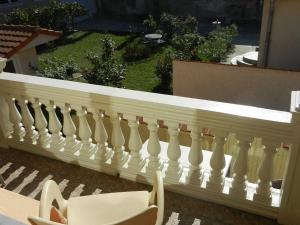 una barandilla blanca en un balcón con 2 sillas en Guesthouse Ellite, en Požarevac