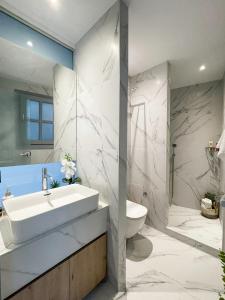 a white bathroom with a sink and a toilet at Lindos Serenity Suites in Lindos +77 photos