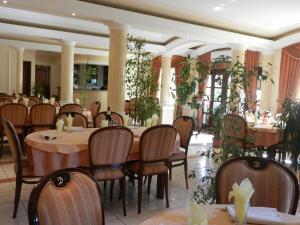 een eetkamer met tafels, stoelen en planten bij Guesthouse Ellite in Požarevac