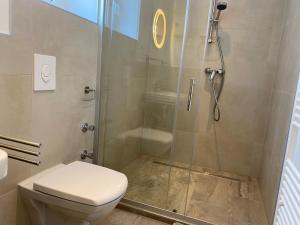 a bathroom with a toilet and a glass shower at interaktiv . Appartements in Heiligenhaus