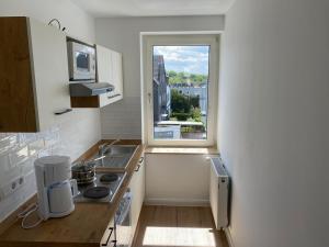 a kitchen with a sink and a window at interaktiv . Appartements in Heiligenhaus
