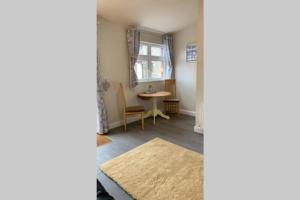 uma sala de estar com uma mesa e uma janela em The Strand Awaits Apartment em Cork