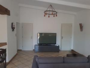 a living room with a couch and a flat screen tv at Maison à la semaine in Vitrolles