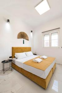 a bedroom with a large bed with white walls at Alia Apartments in Rhodes Town