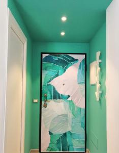 a painting of two umbrellas on a green wall at CasAgnese Sanremo in Sanremo