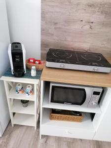 a kitchen counter with a microwave and a stove at Blue Cottage monolocale centro Sciacca in Sciacca