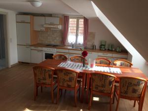 cocina con mesa de madera y sillas en Haus Heinrich Heine, en Ilsenburg