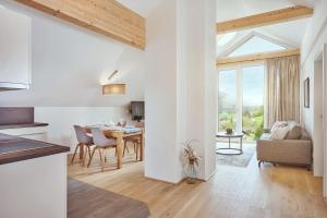a kitchen and living room with a table and chairs at Die Tauplitz Lodges - Bergblick B7-2 by AA Holiday Homes in Tauplitz