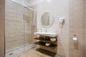 un bagno con lavandino e doccia di Porta D'Oro Charming House ad Alghero