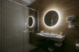 un bagno con lavandino e specchio di Porta D'Oro Charming House ad Alghero Altre 17 foto