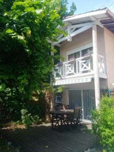 a patio with a table in front of a house at Villa Le Mauret in Andernos-les-Bains