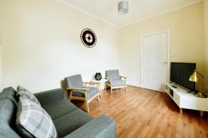 a living room with a couch and a tv at Guest Homes - Gerald House in Swansea