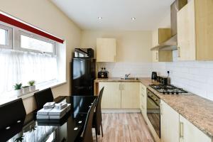 a kitchen with a table and a black refrigerator at Guest Homes - Gerald House in Swansea