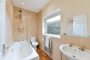a bathroom with a tub and a sink and a toilet at Host & Stay - Gerald House in Swansea +30 photos